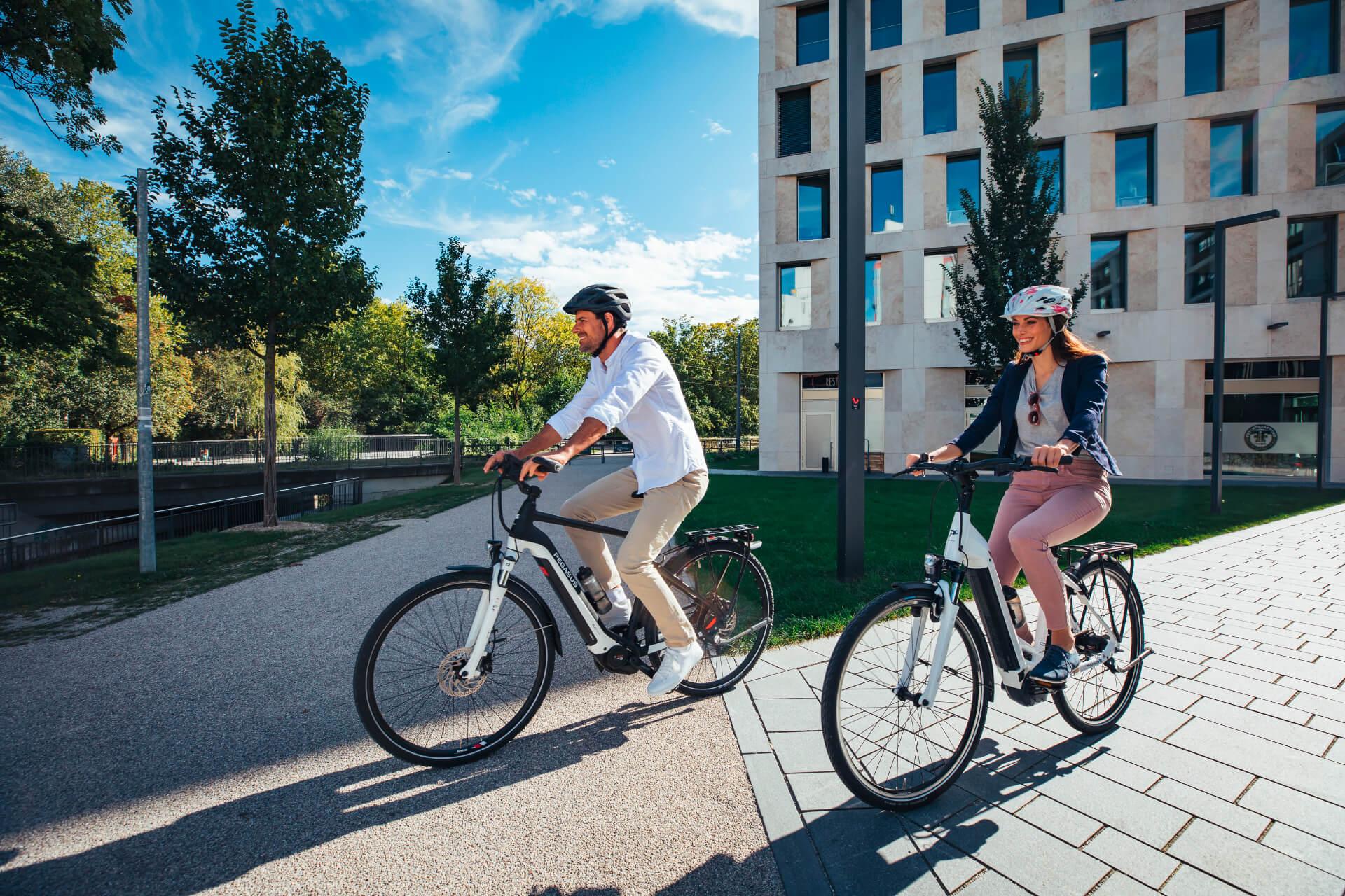 Fiatal pár teker ebike-kon egy lakóparkban
