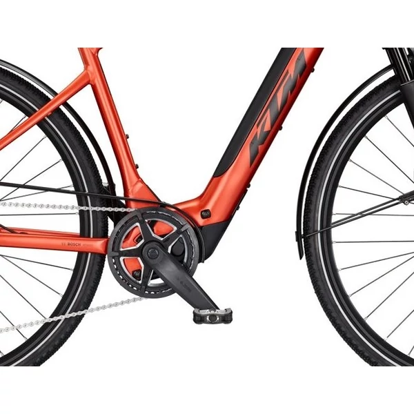 KTM Macina Sport SX 10 elektromos kerékpár narancs színben férfi vázzal